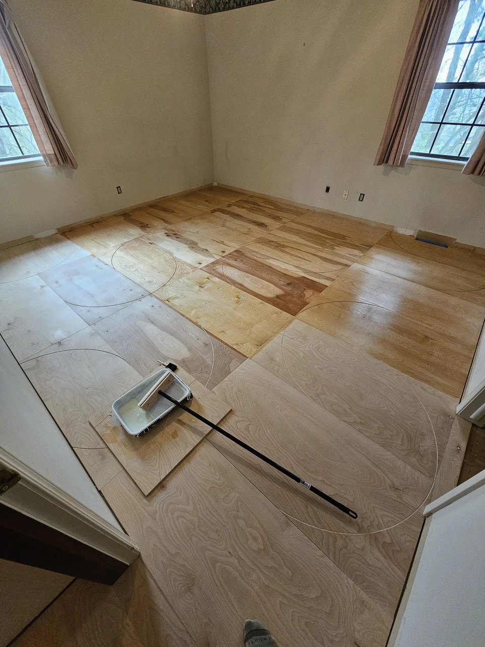 The finished birch floor with twin arches at left and raking window light down the room.