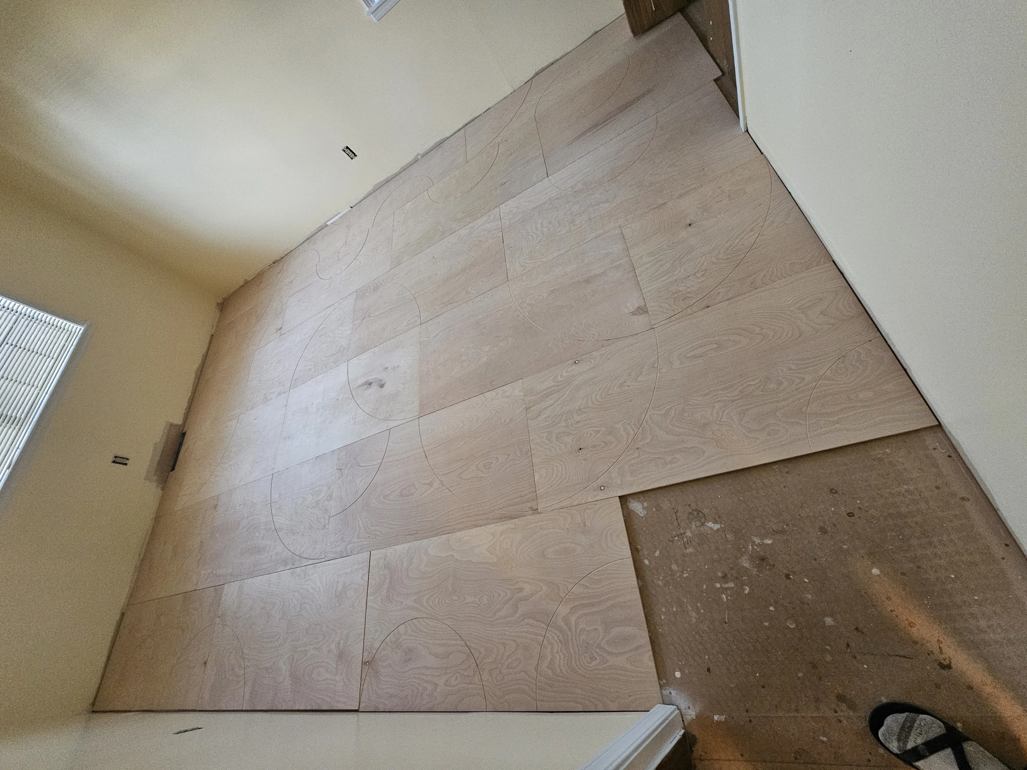 The finished floor showing multiple intersecting curved inlays across the room.