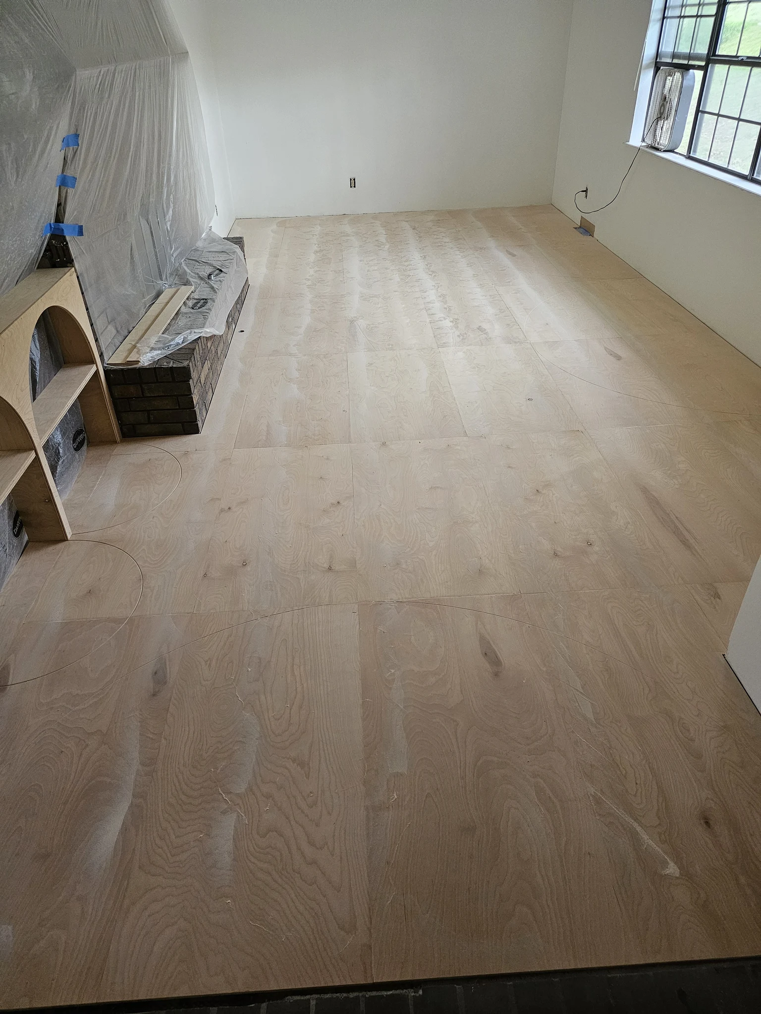 A room stripped back to bare subfloor before new flooring.