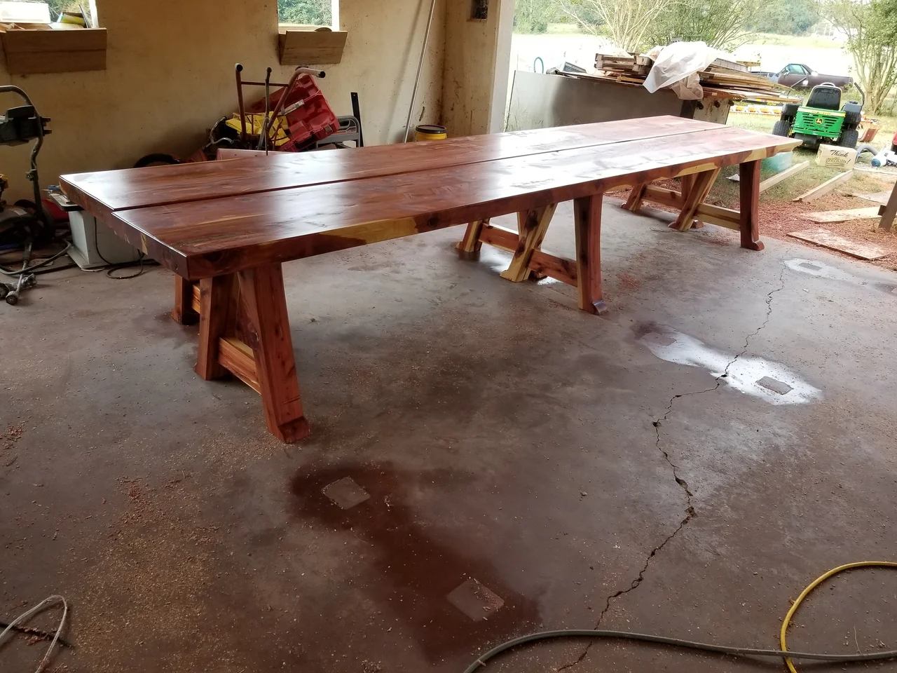 A finished live-edge cedar table on a pegged trestle base.