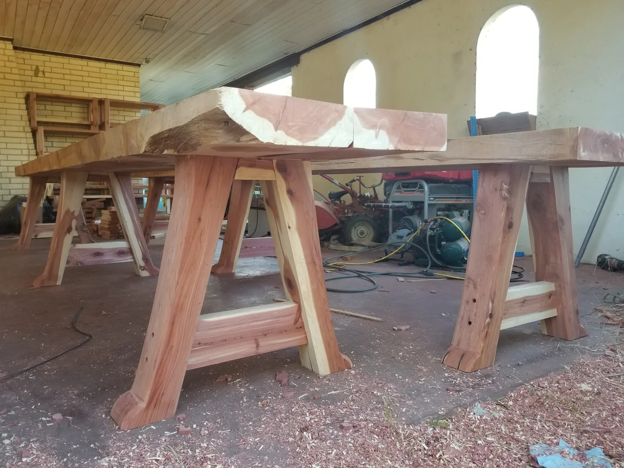 A long communal cedar table with matching benches assembled in the shop.