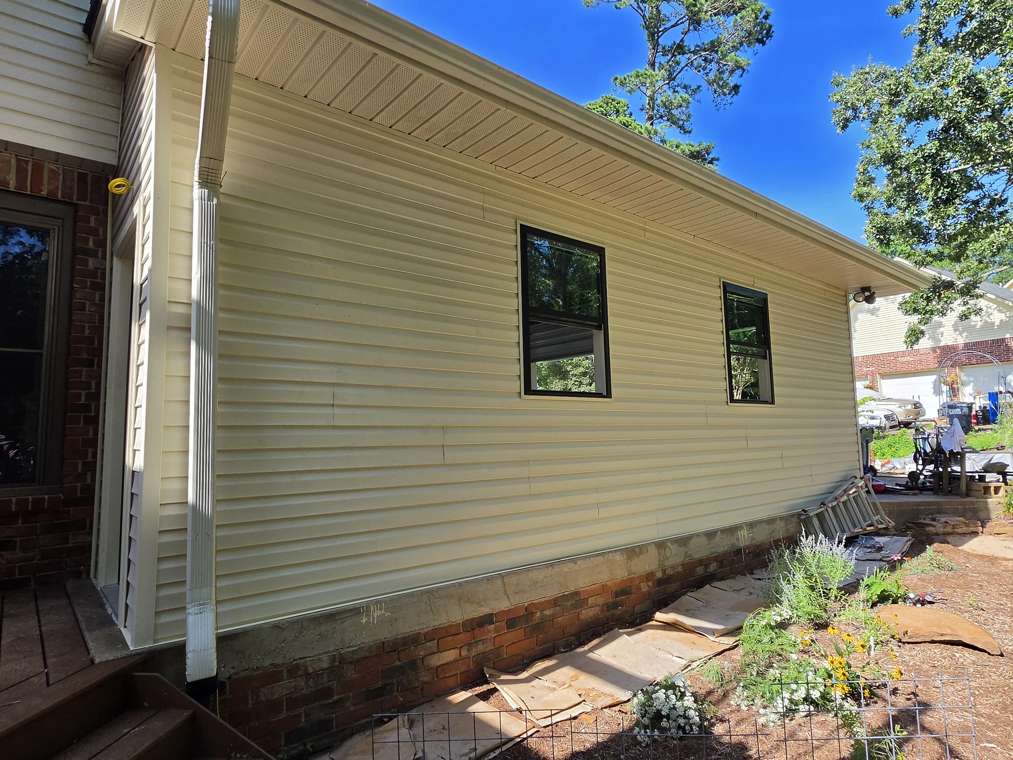The finished exterior side elevation with new siding and windows.