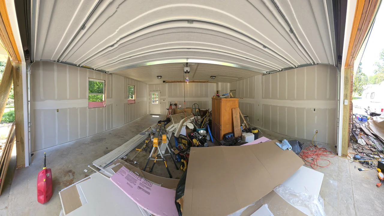 Interior with drywall going up beneath the white metal ceiling.