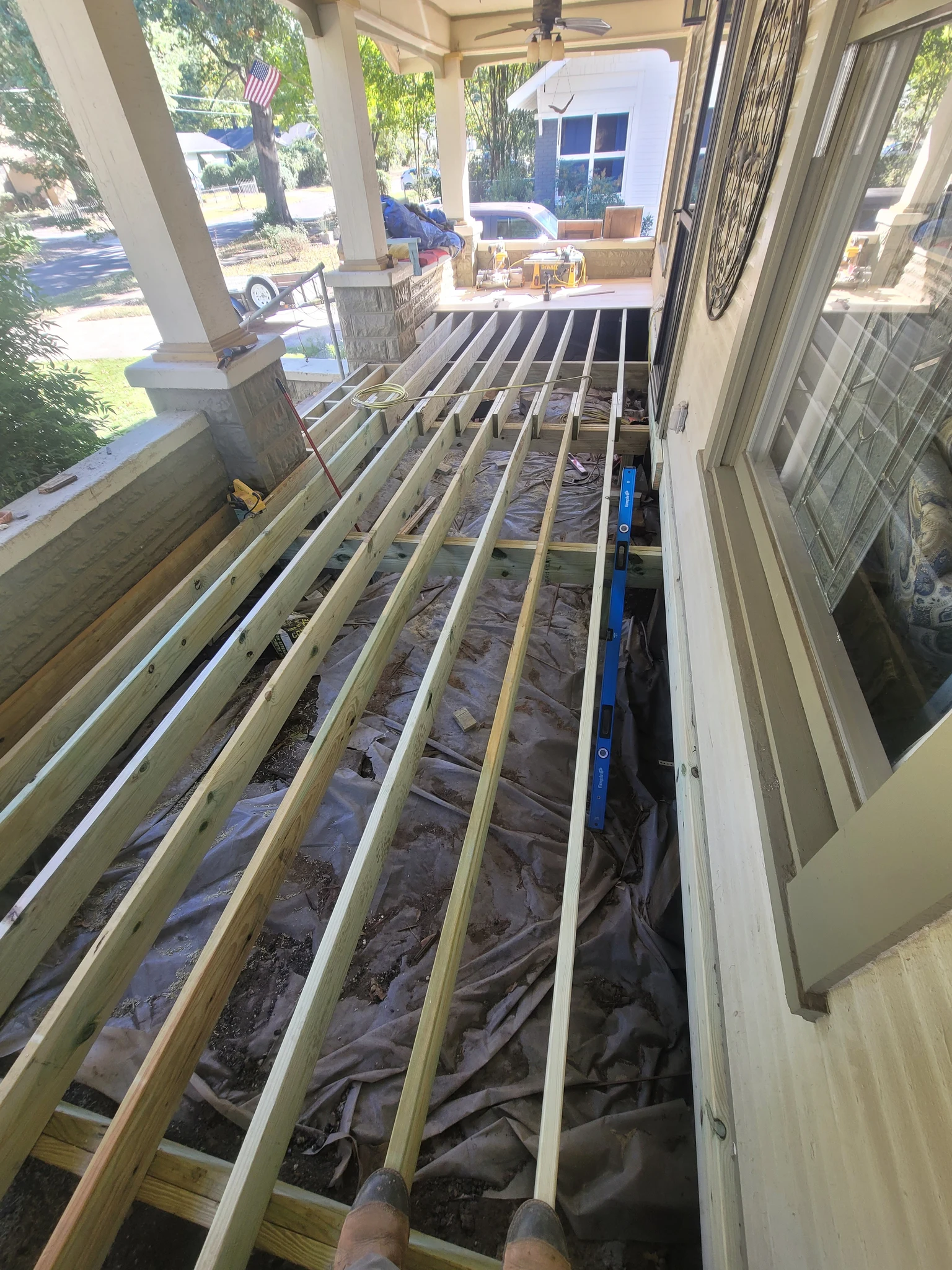 New joists run beneath the original porch columns.