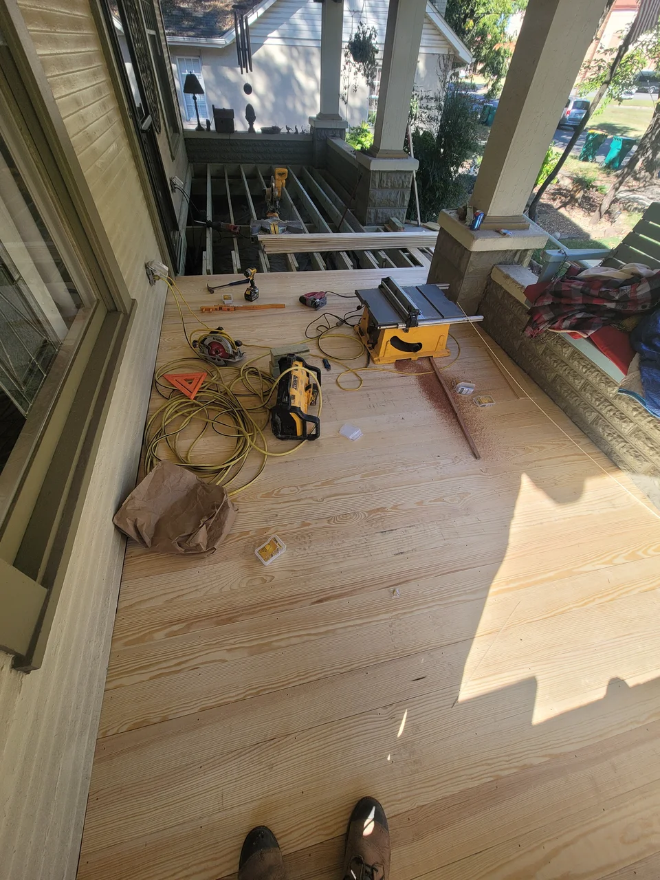Tongue-and-groove porch flooring being laid.