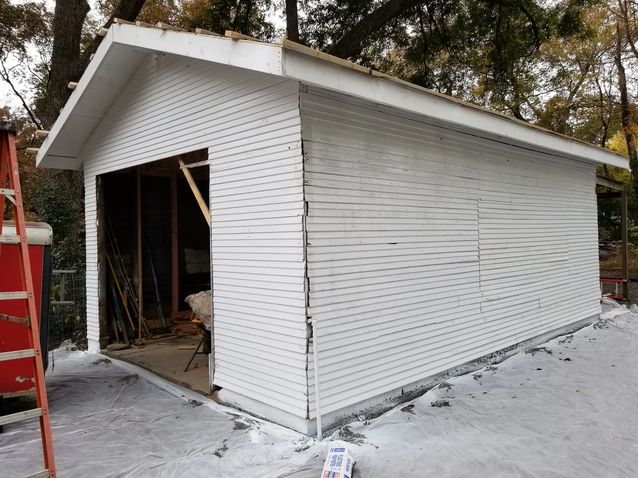 The detached garage shell reframed with new gable framing and siding.