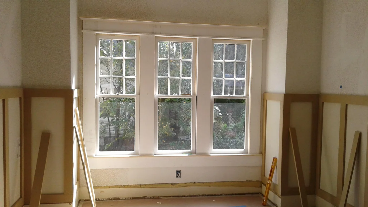 A room stripped back to bare walls with its original doors and tall windows.