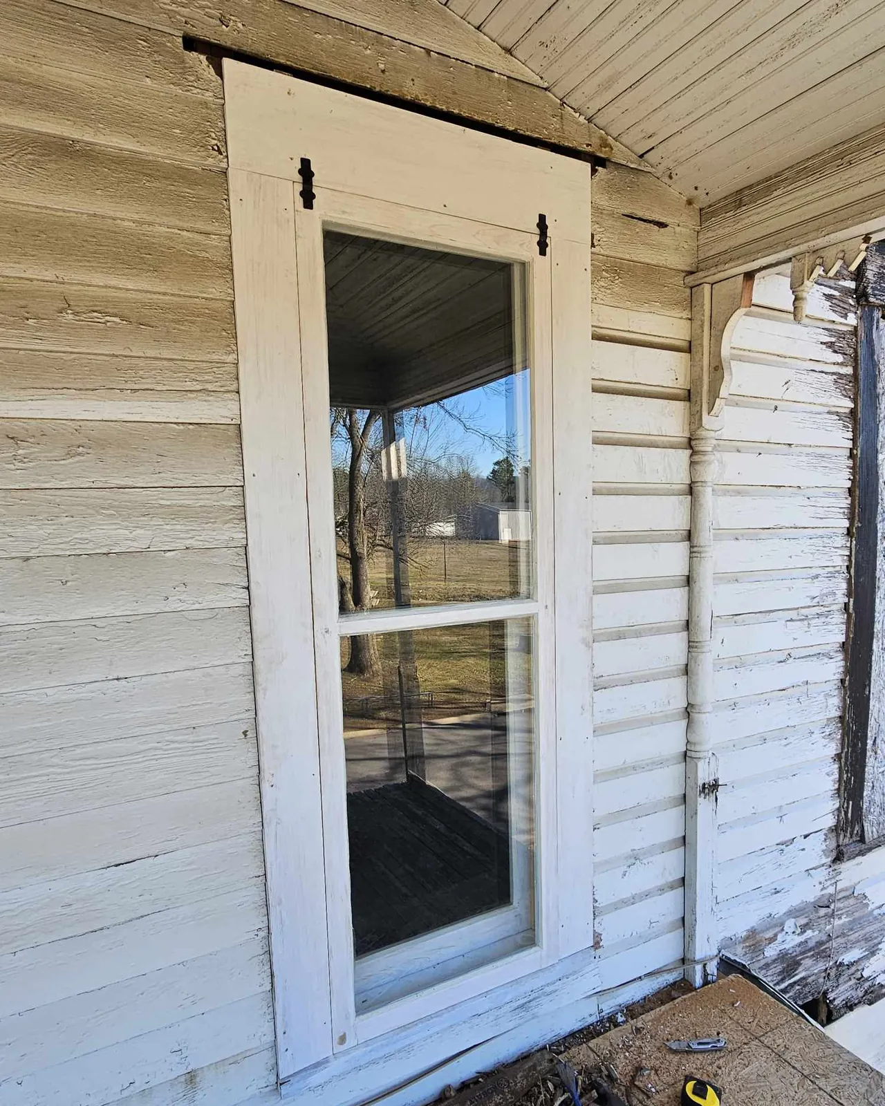 The same wall after restoration: rebuilt sash, sound trim, fresh paint.