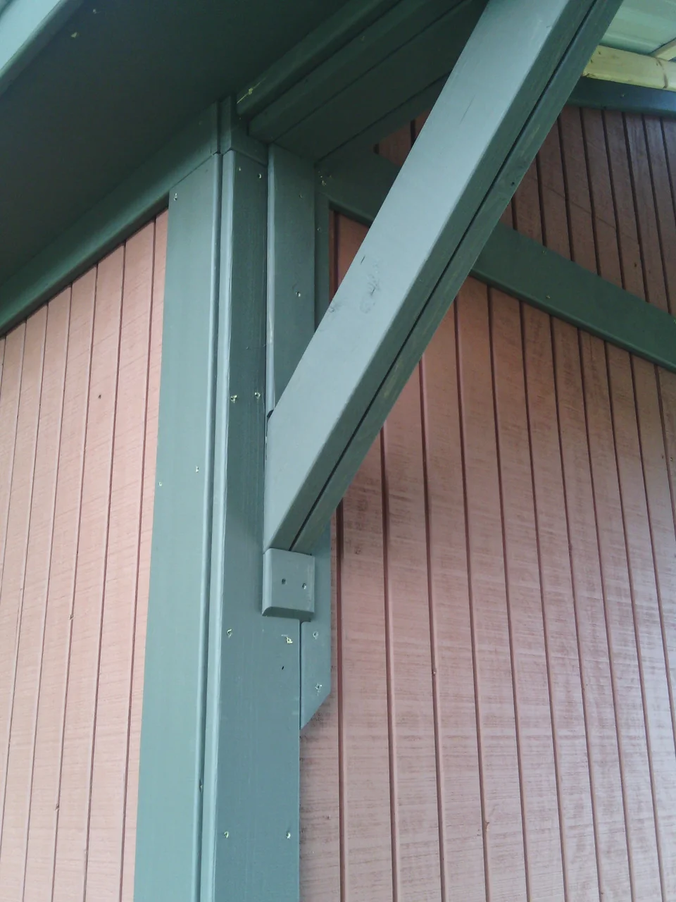 Detail of a painted exposed timber bracket carrying the breezeway roof.