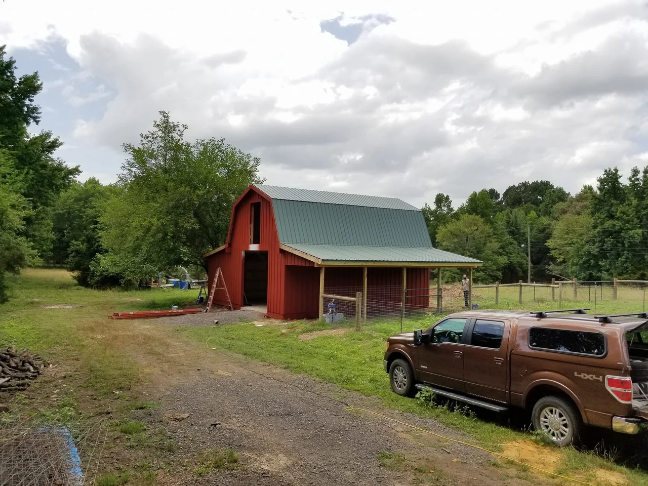 The completed barn seen across the property with a truck parked alongside.