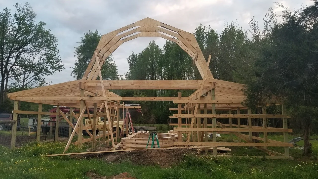 Gambrel roof trusses assembled on site with plywood gussets during construction.