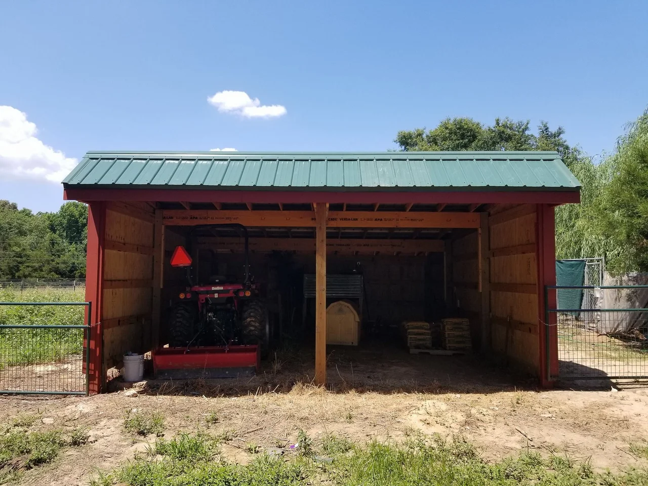 The finished barn's open bay with a tractor parked inside.