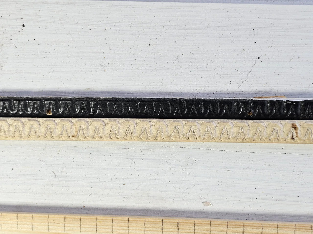 Detail of finished carved moulding profiles laid side by side.