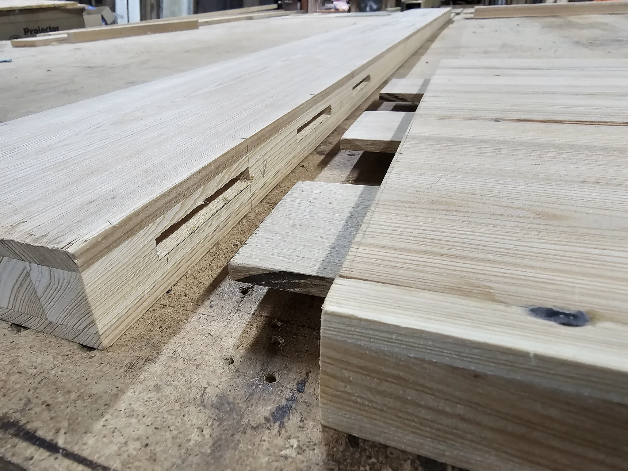 Milled door parts showing cut mortises waiting for assembly.
