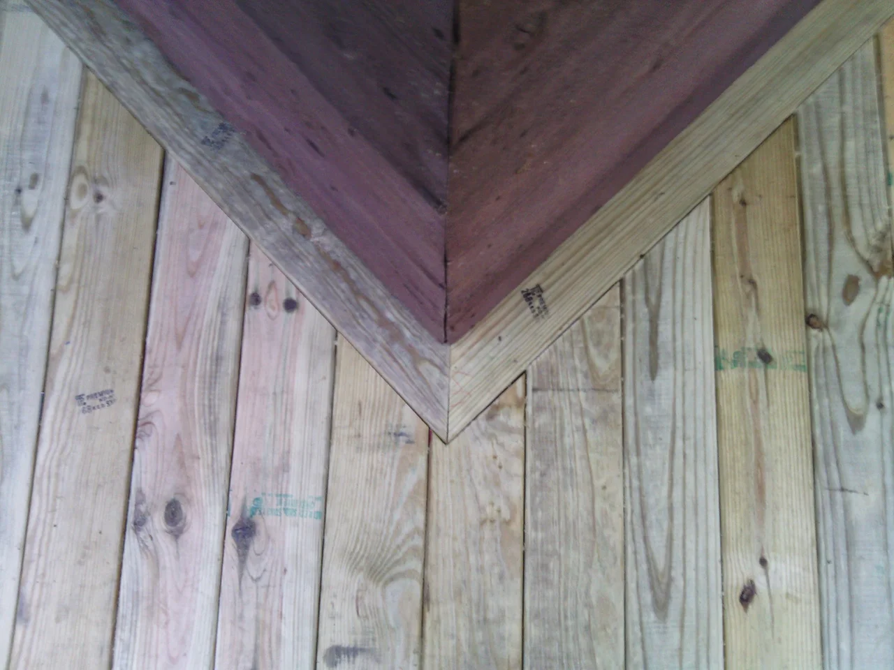 A double mitre driving into an inside corner against dark siding.
