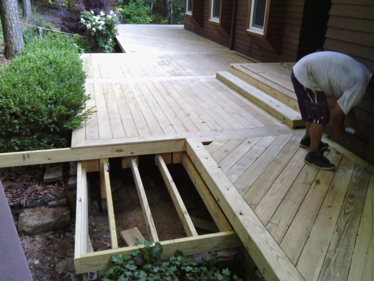 Deck boards being laid over the frame, with the stepped border already run.
