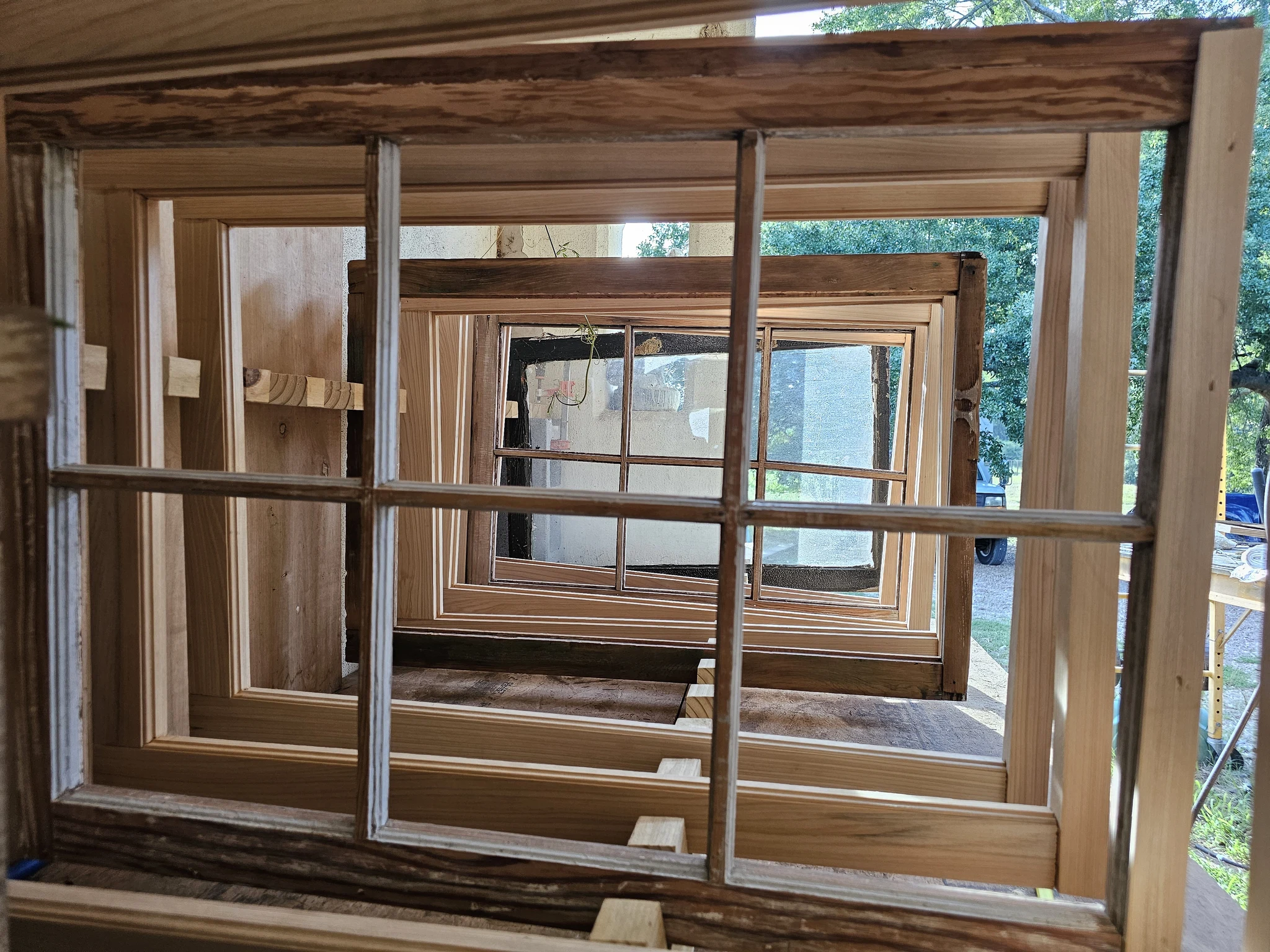 Nested window sashes in bare wood with fresh glazing compound at the muntins.