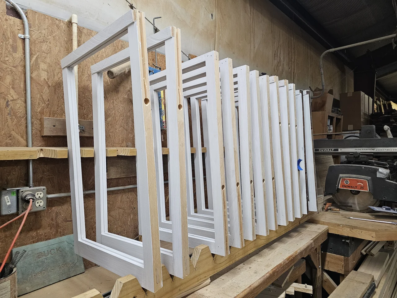 A shop bench holding primed window sashes waiting to be glazed.