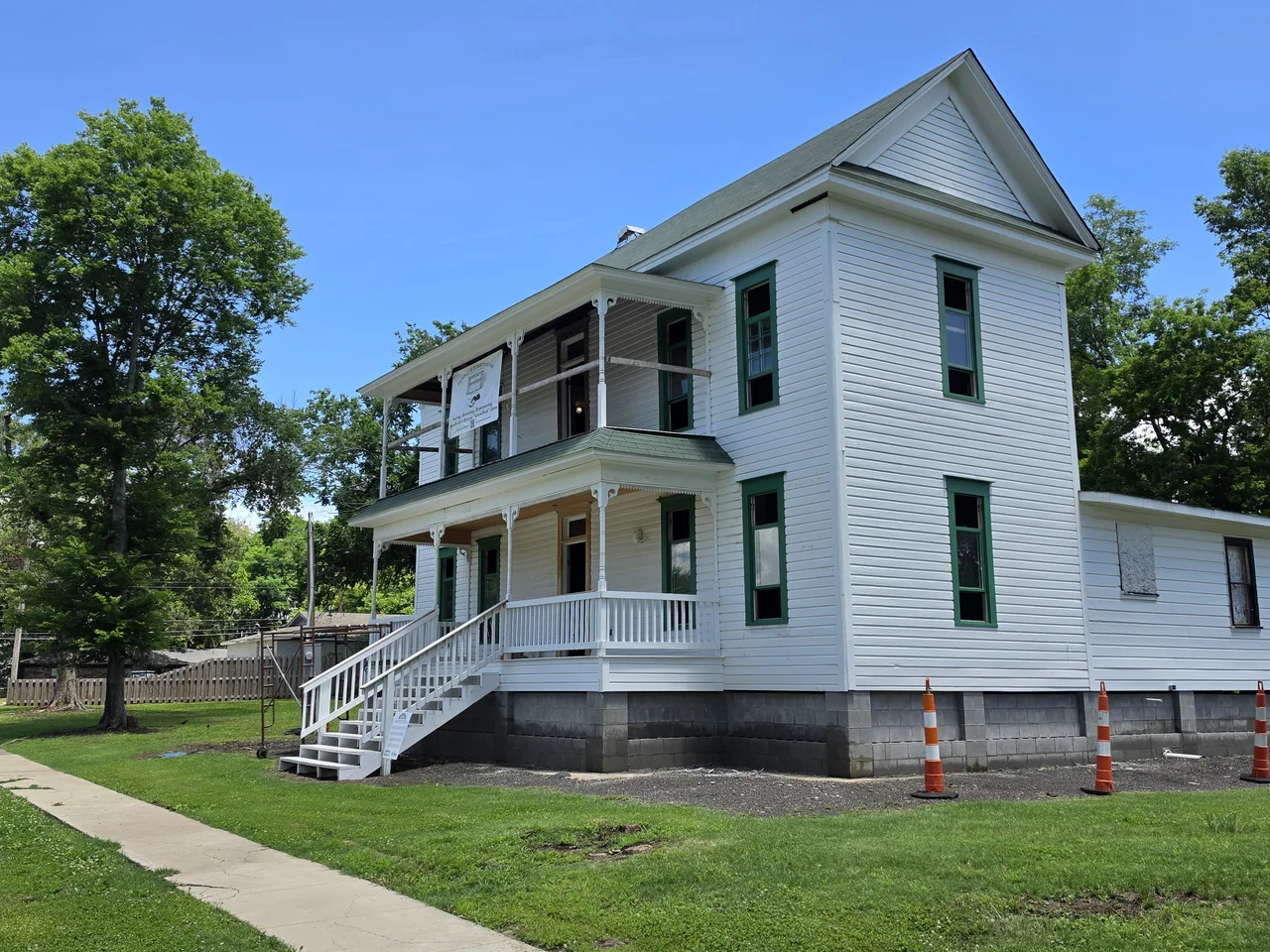 The restored historic house in full sun under a blue sky.