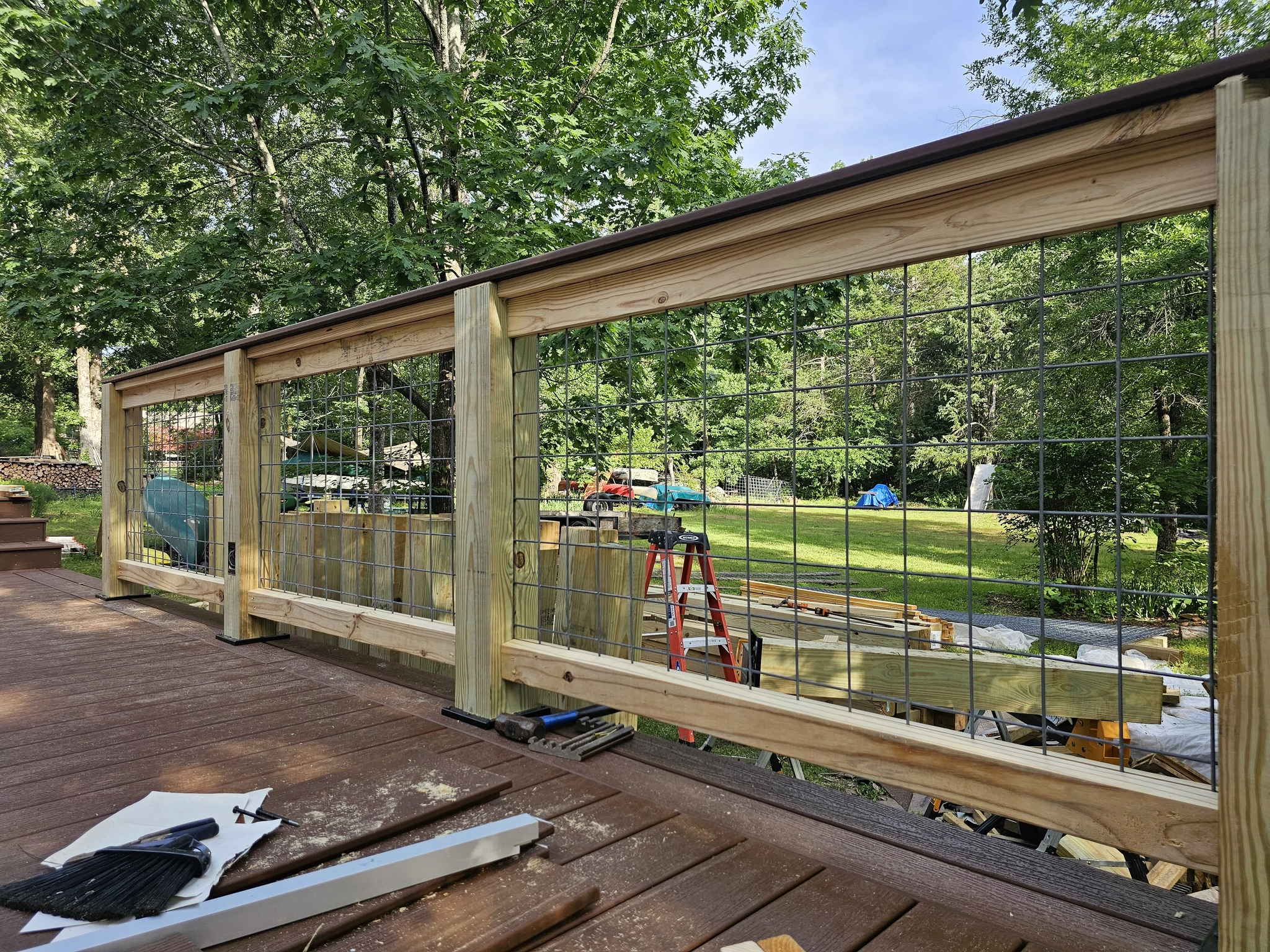 The finished deck with its horizontal wire railing looking into the trees.