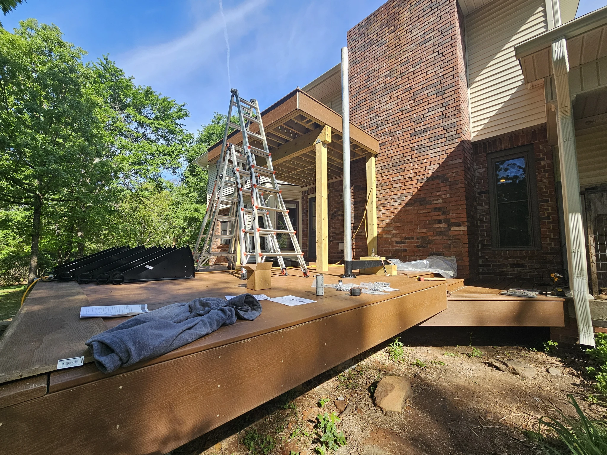 The finished deck surface with a ladder leaning against the house, before the spiral stair was set.
