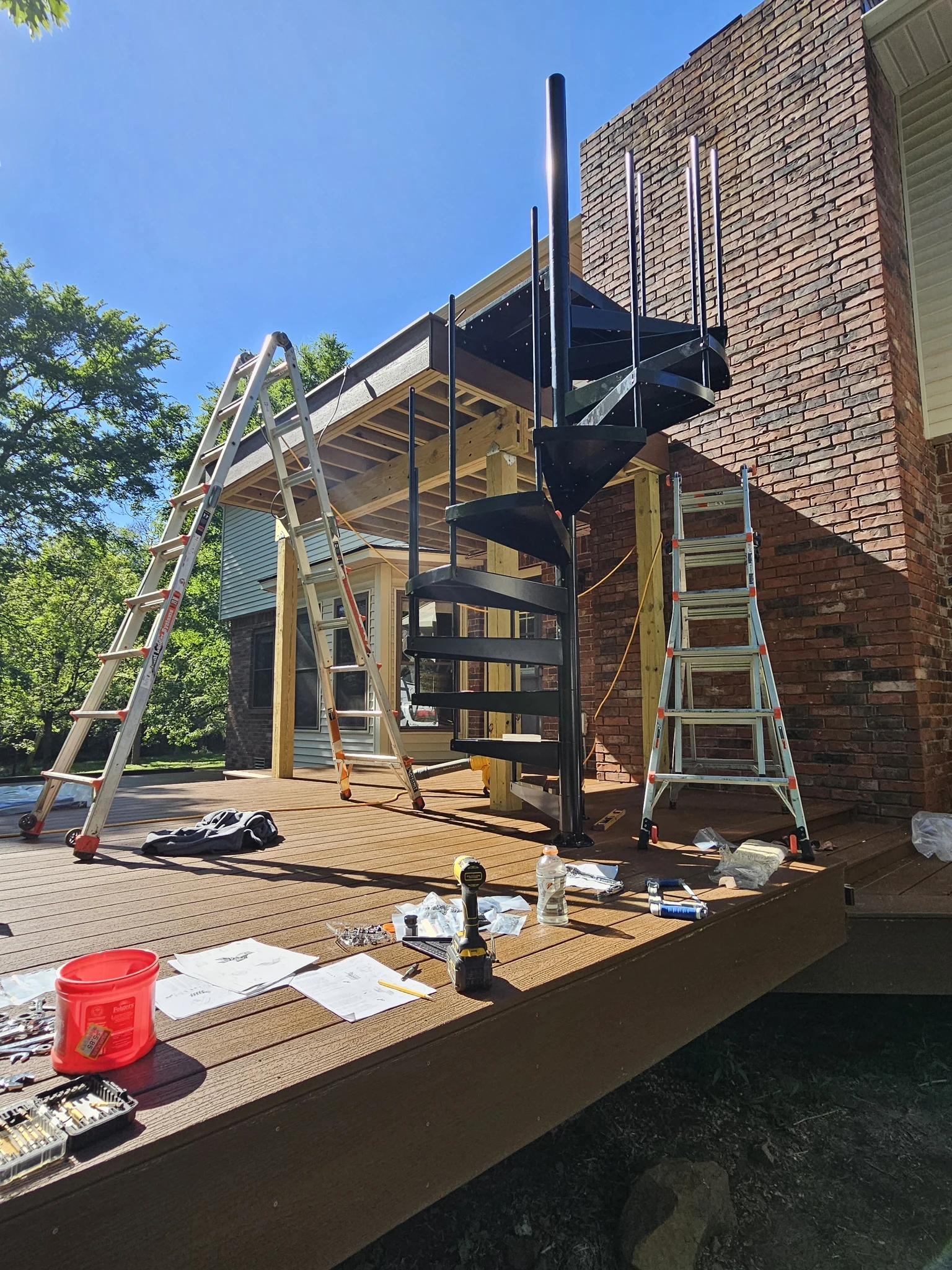 The set spiral stair seen from the far end of the deck, ladders and fixings still on the boards.