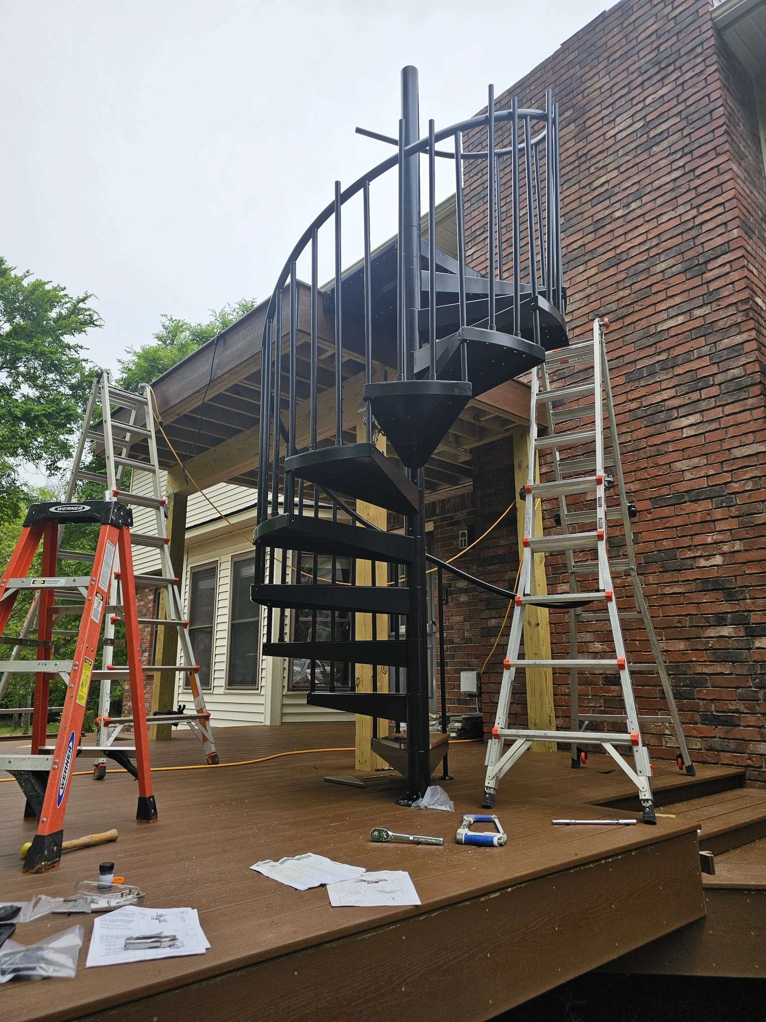 The stair and its rail seen from deck level, ladders still standing alongside.