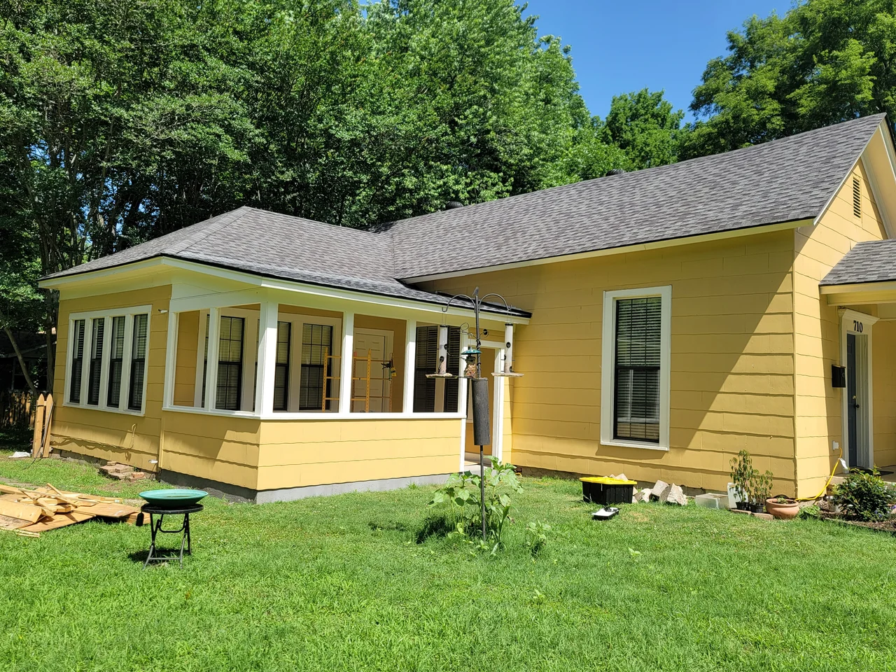 The porch exterior clad in yellow siding matching the existing house.