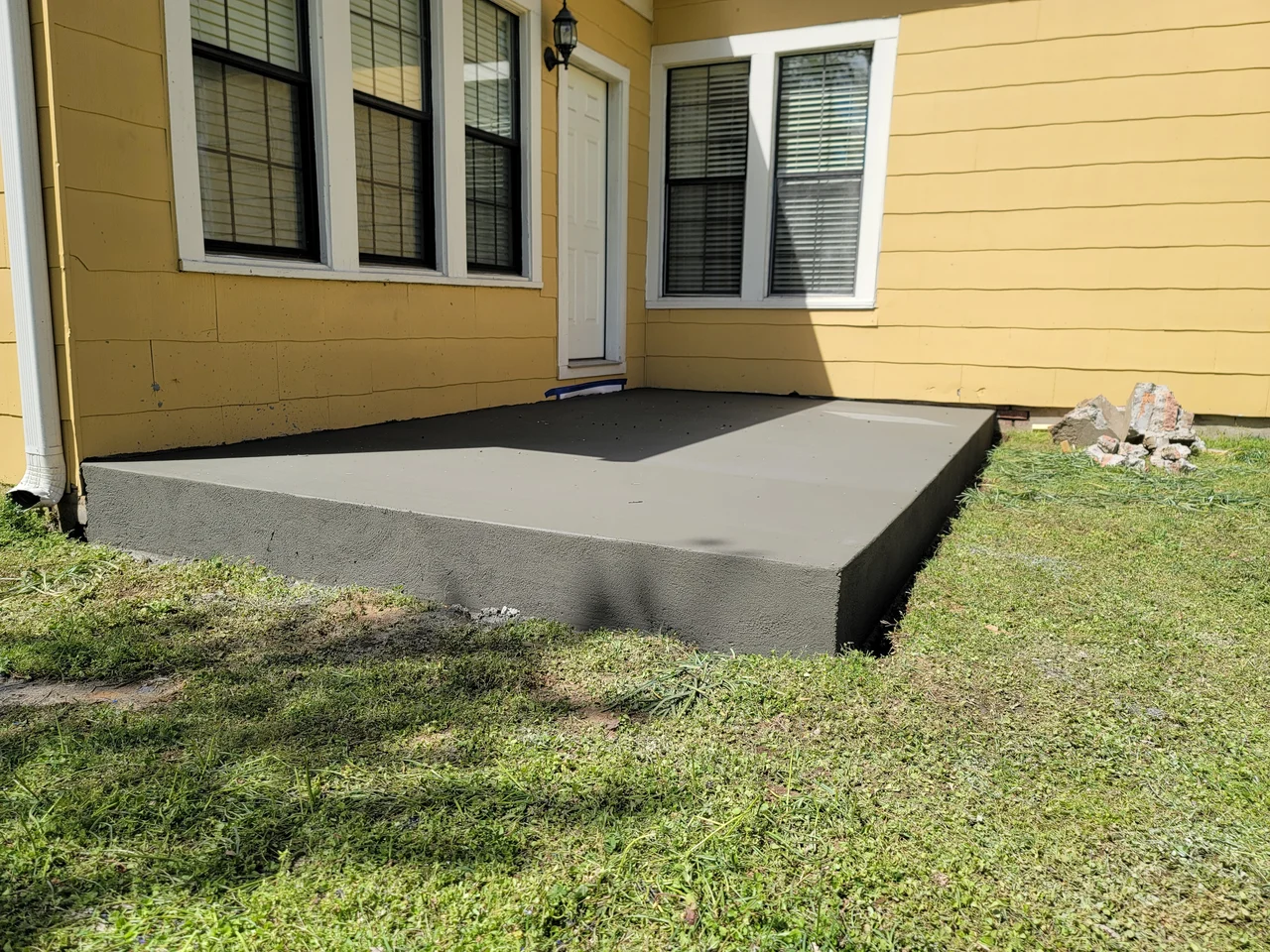 A freshly poured concrete slab for the porch addition.