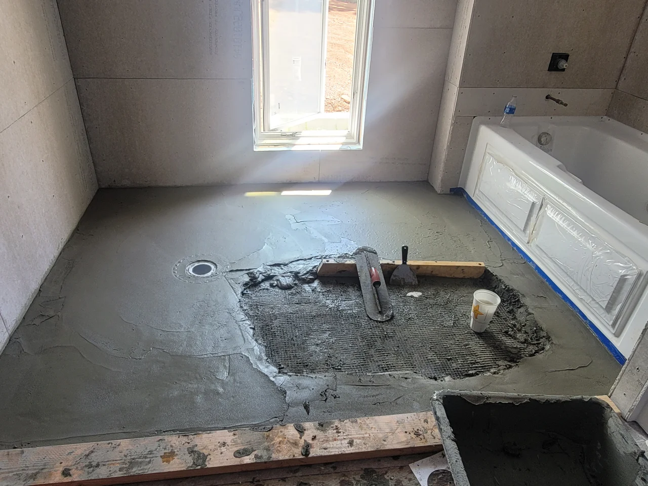 A completed mud-bed floor with the tub set alongside.