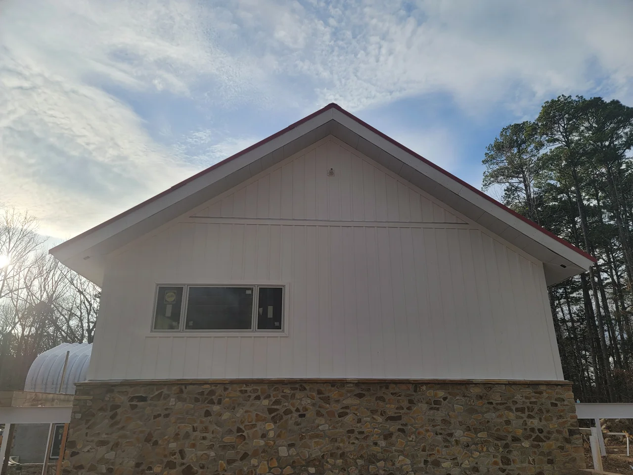 The gable end with the steel arch building visible behind.