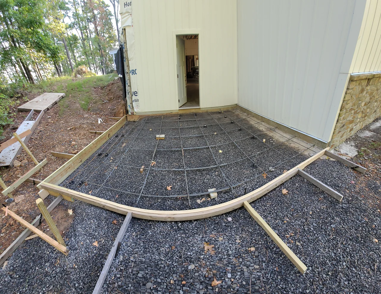 A curved concrete apron formed in timber with reinforcing mesh laid over gravel.