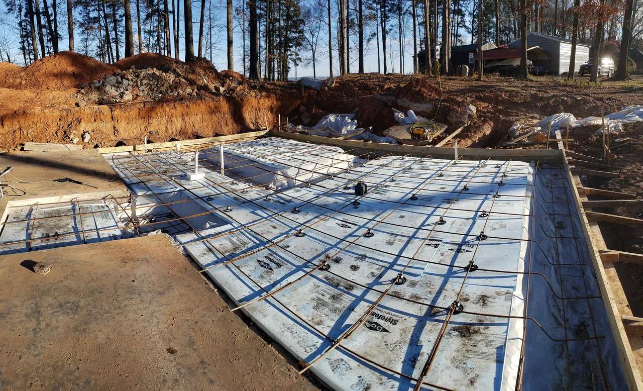 Rebar and tubing laid over rigid foam insulation before the slab pour.