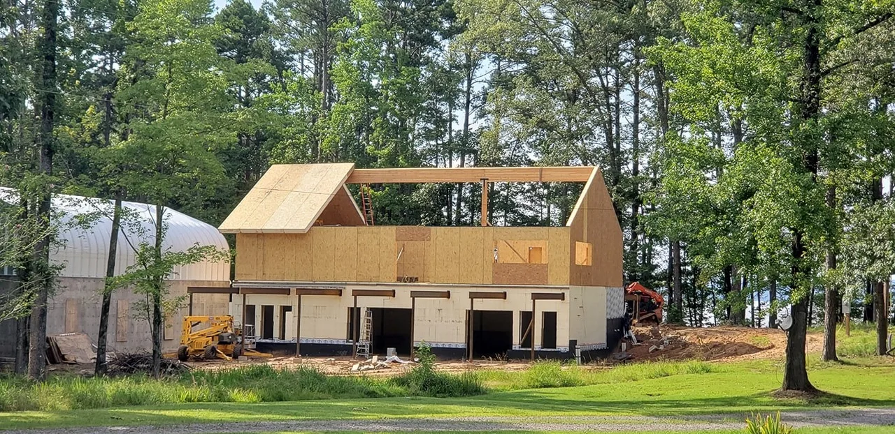 Early framing rising off the concrete garage structure.