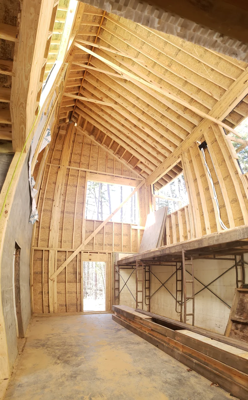 Interior framing of the vaulted roof structure seen from the floor.