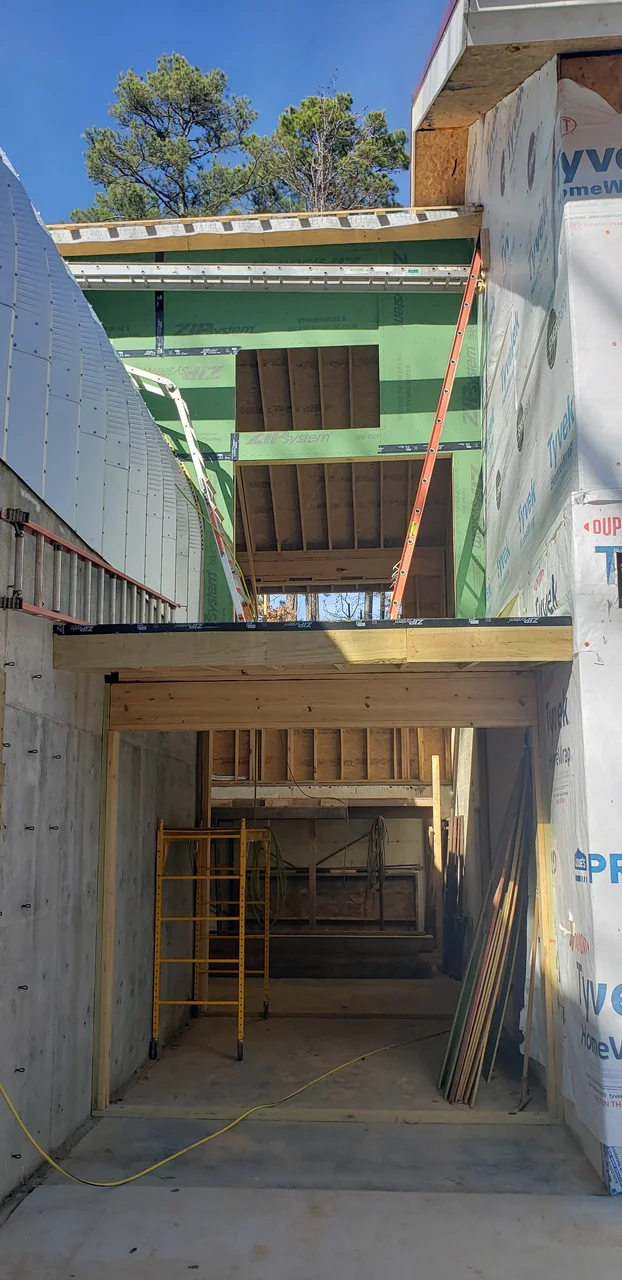 Interior framing with sheathing and a stair opening cut through.