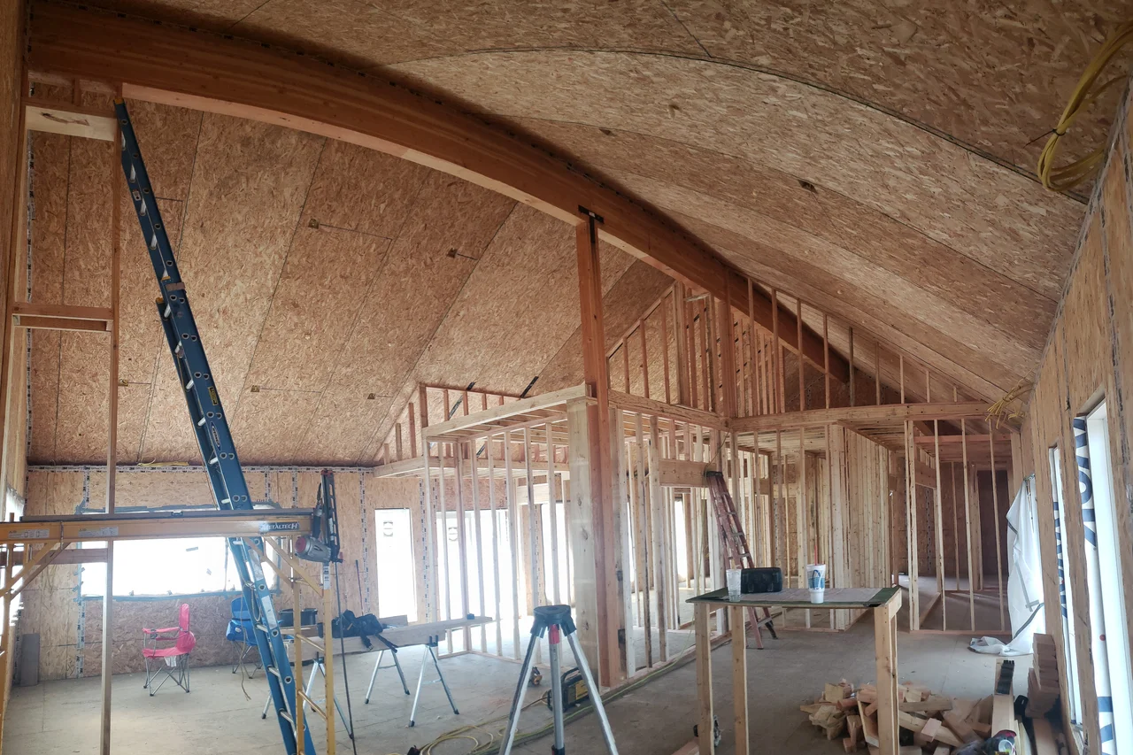 Interior view of the curved arch ceiling in sheathing, with framing below.