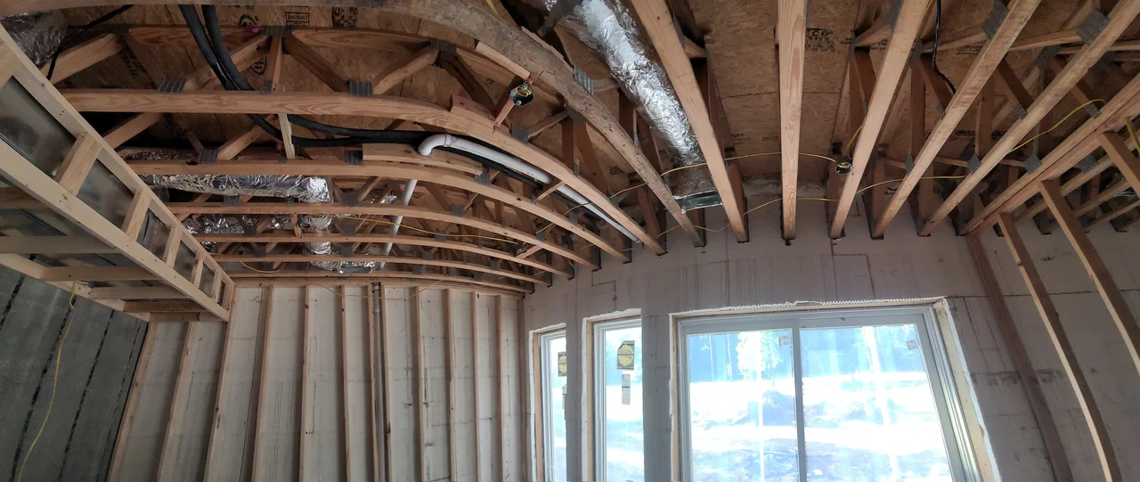 Interior ceiling framing with ductwork run between the members.
