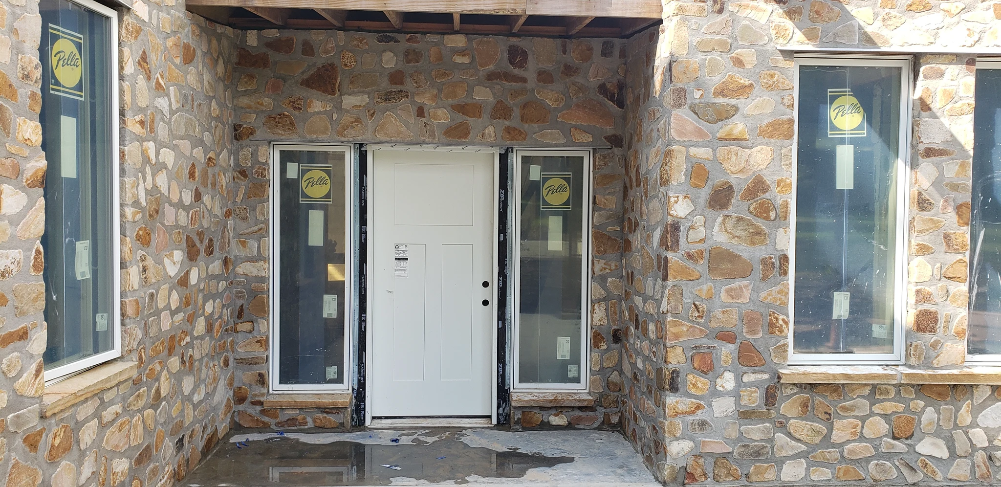 Finished stone around the entry door, curving away on both sides.