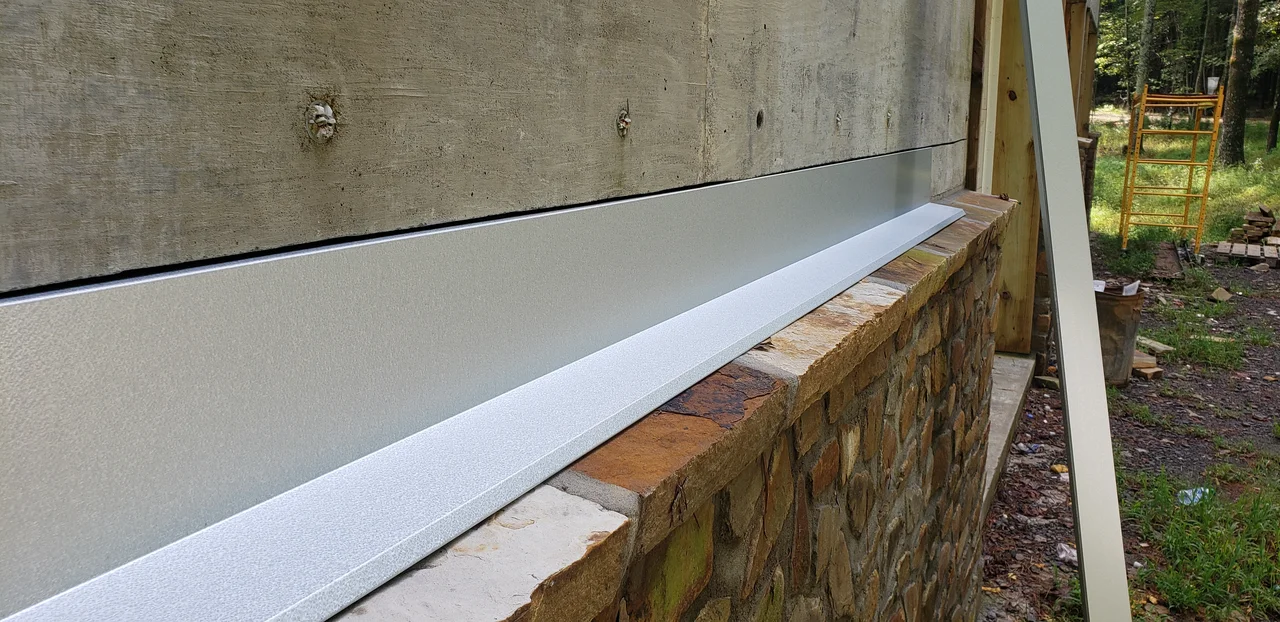 Close view of the stone wall cap and white trim detail.