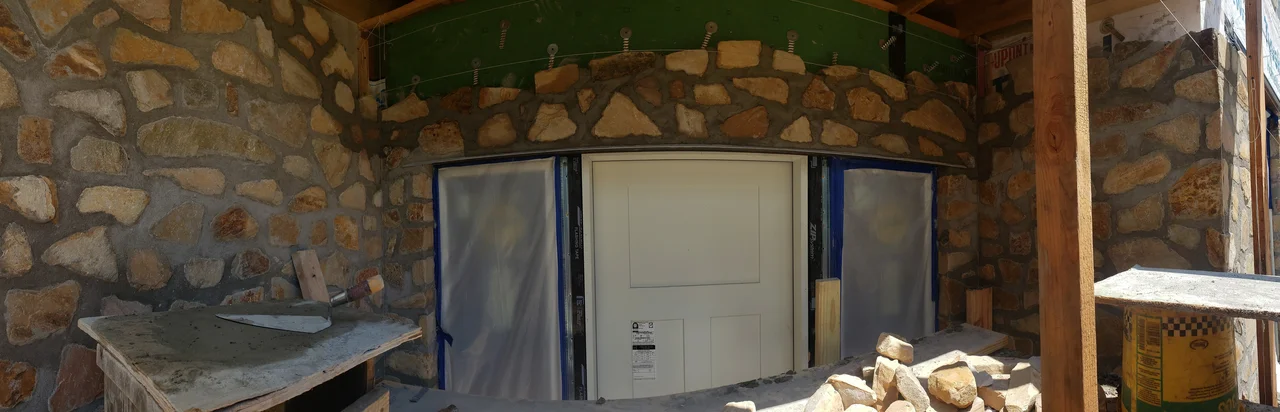 Interior view of the stone wall meeting the sheathed structure.