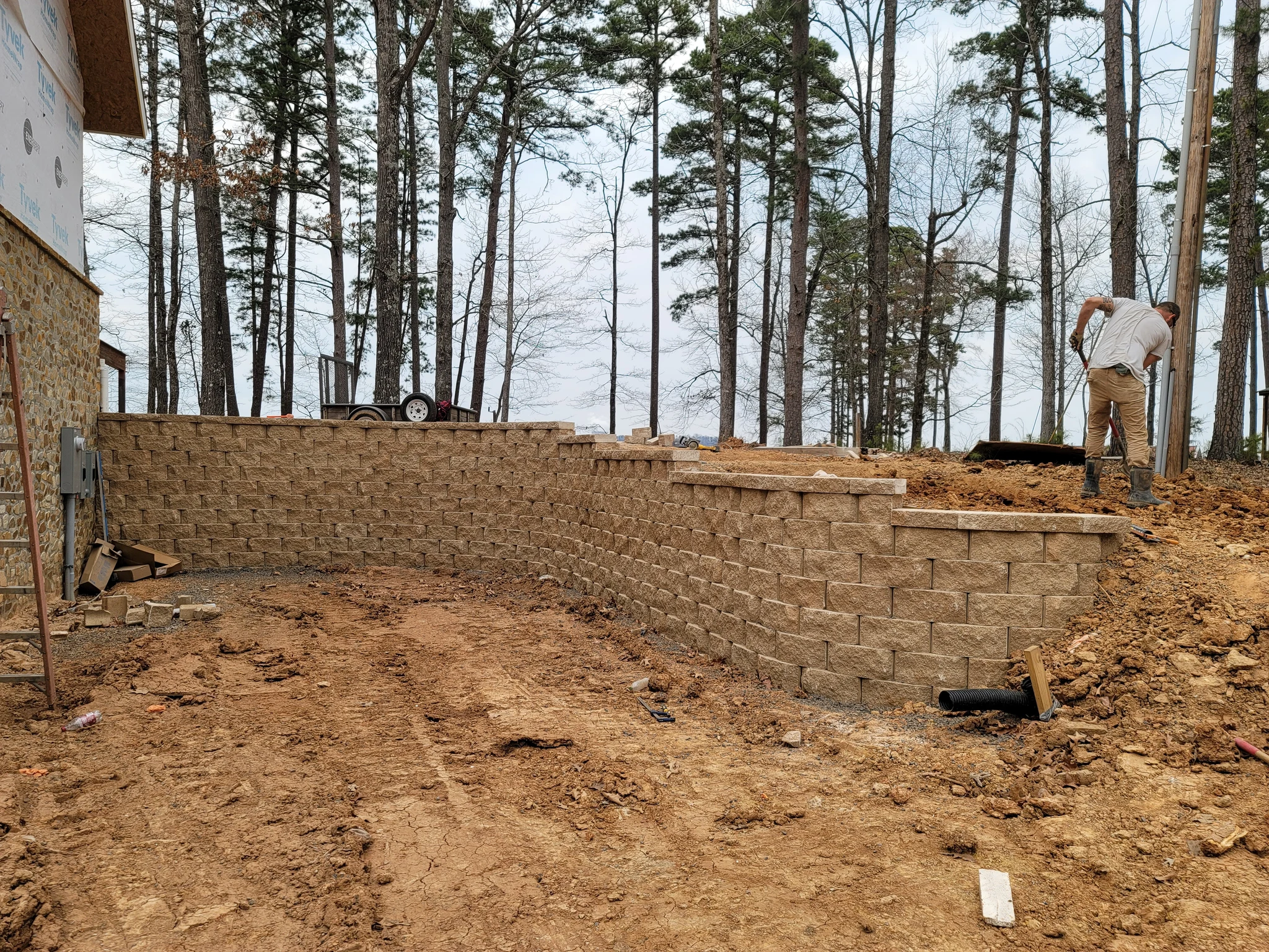 A long curved segmental retaining wall holding back the slope.