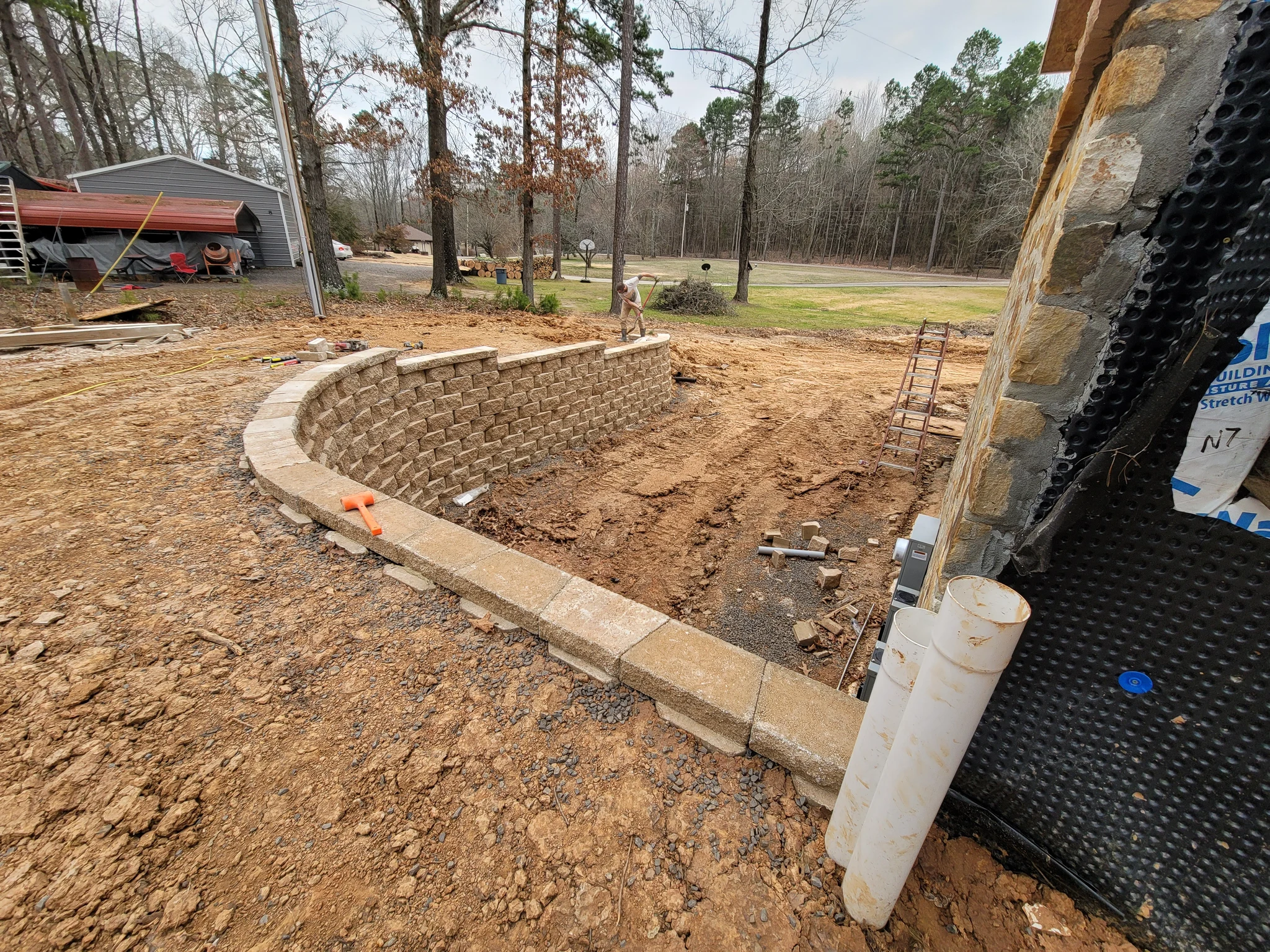 A completed curved segmental retaining wall with drainage in place.