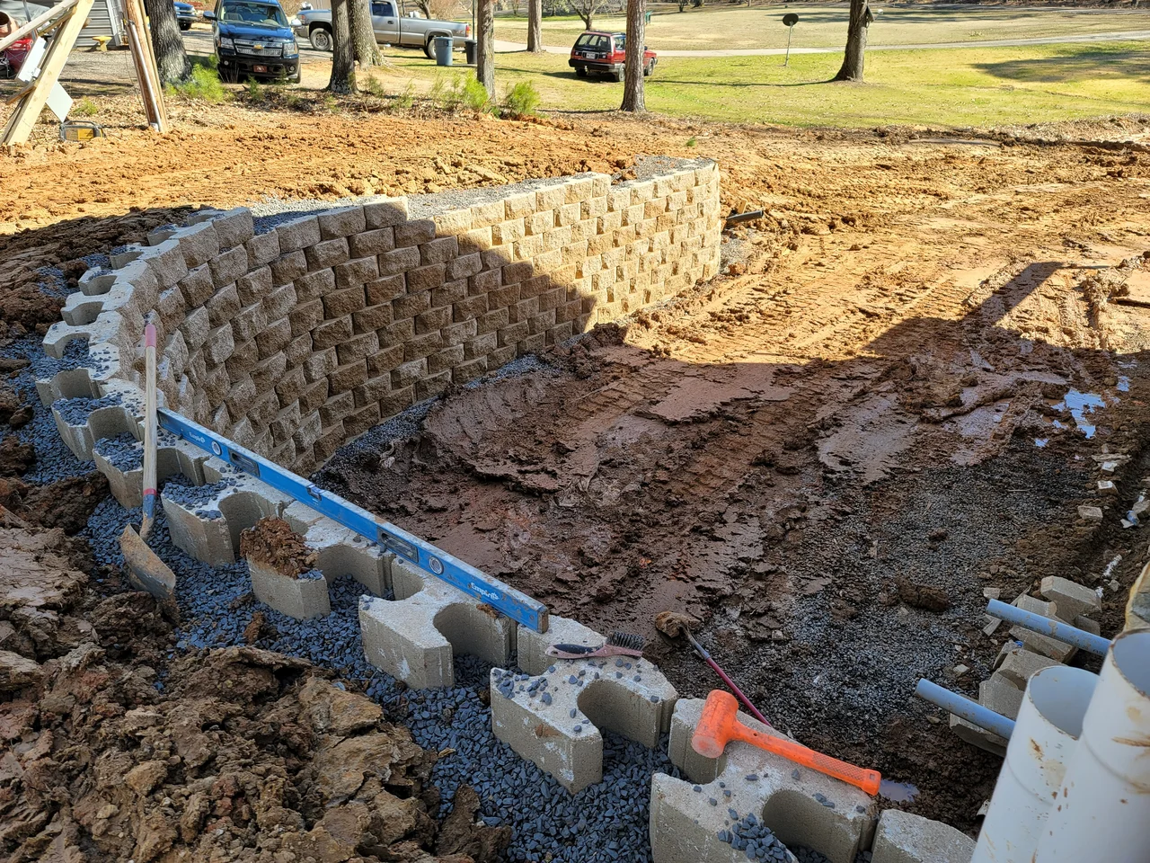 Perforated drainage pipe laid behind a segmental retaining wall.