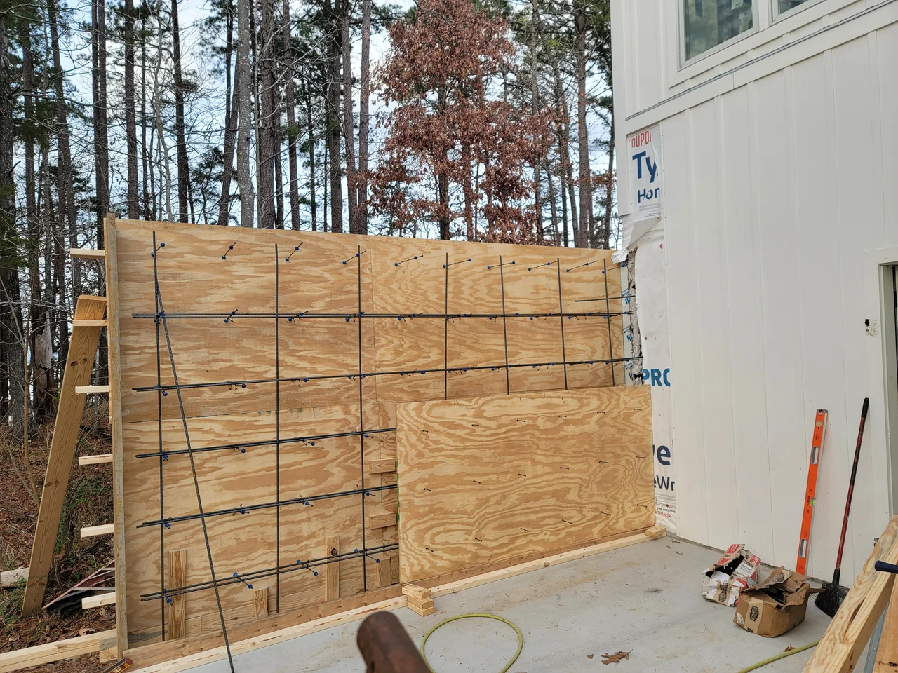 The outer face of the braced formwork panel against the house.