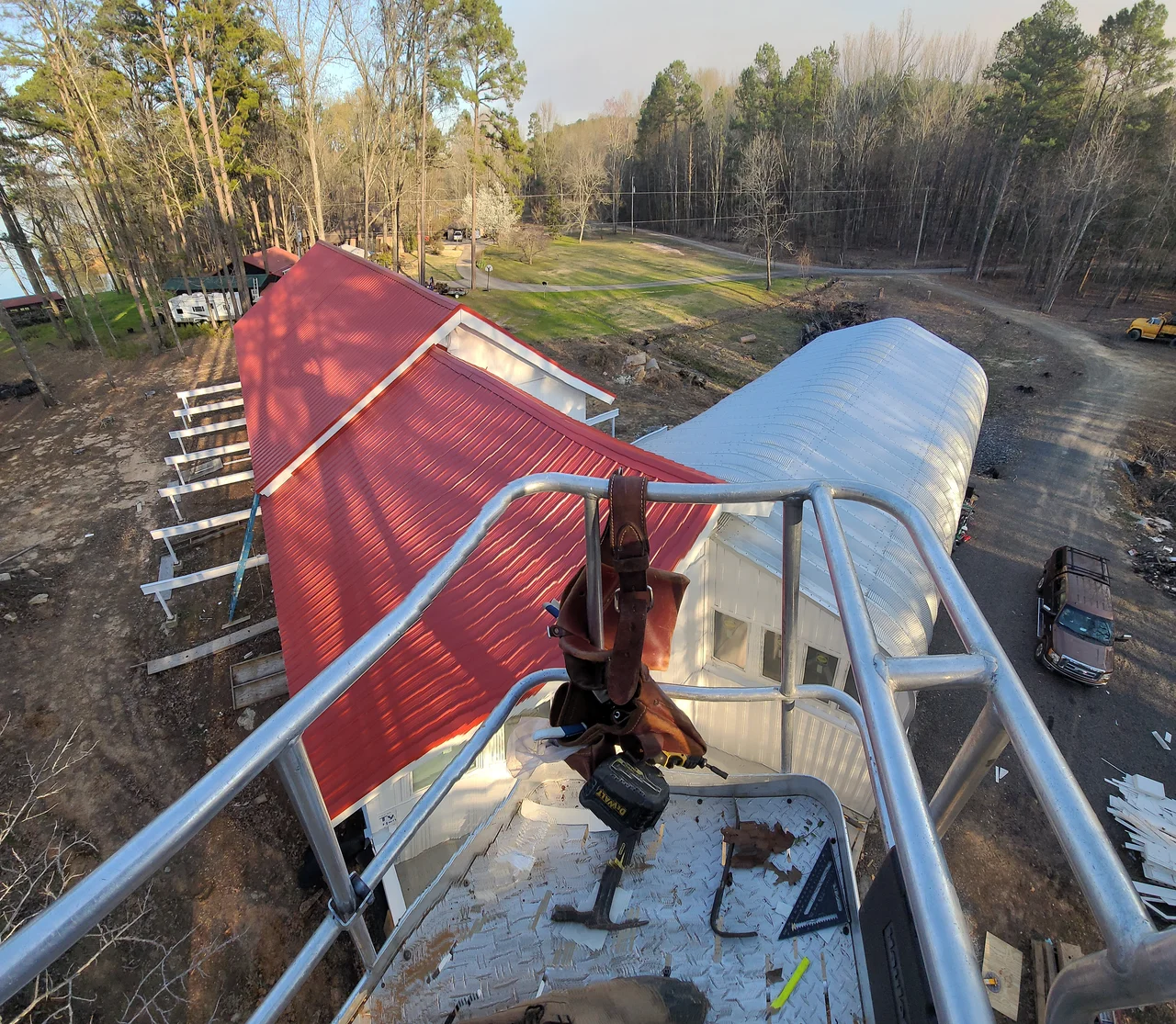 A roofer working the standing-seam roof from above.