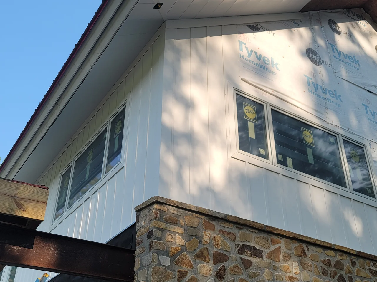 Close view of the wrapped soffit and fascia above the stone base.