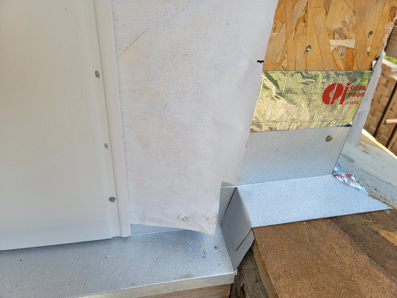 Close detail of rigid insulation and flashing at a wall junction.
