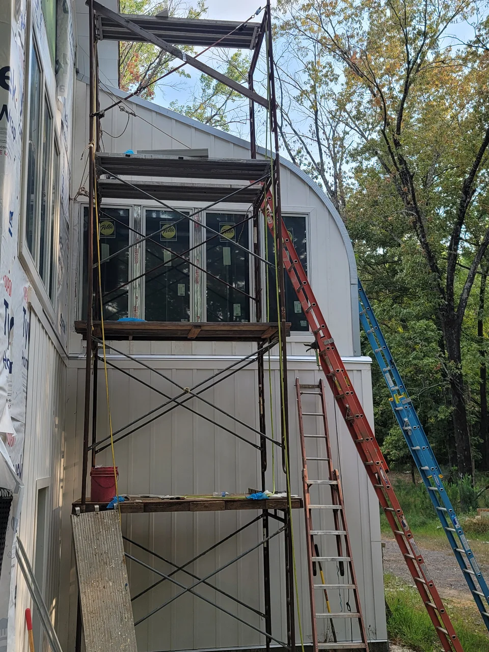 Scaffolding stacked two lifts high against the upper wall.