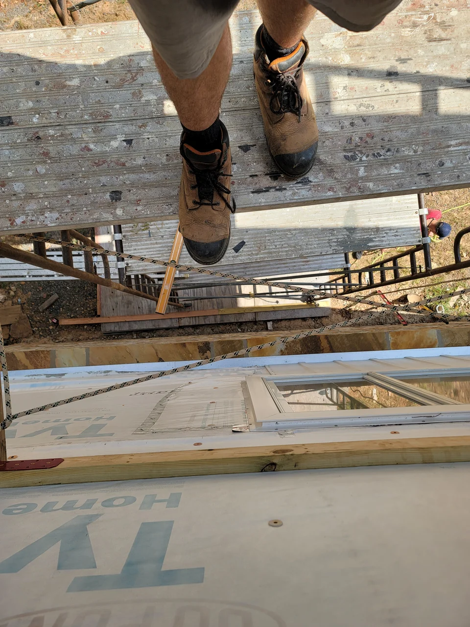 Looking down from the scaffold plank at the wall below.